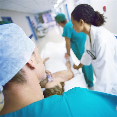 Medical team moving patient on gurney Stock Photo - Premium Royalty-Free, Code: 632-01152811