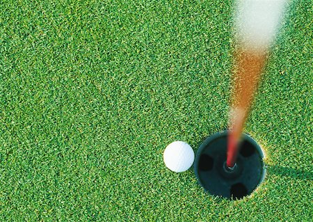 rolling over - Golf ball at edge of hole, view from directly above Foto de stock - Sin royalties Premium, Código: 632-01153271