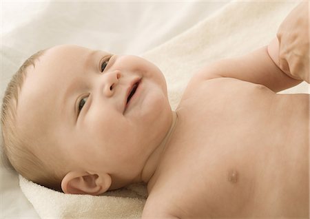 fat laying down - Baby lying on back, laughing Stock Photo - Premium Royalty-Free, Code: 632-01153302