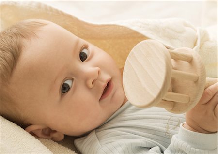 rattling - Baby holding wooden rattle, portrait Stock Photo - Premium Royalty-Free, Code: 632-01153314