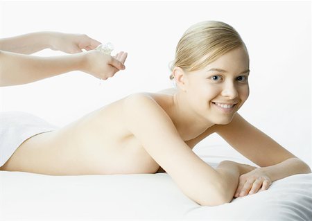 simsearch:632-01153443,k - Woman on massage table, message therapist pouring massage oil into hands Stock Photo - Premium Royalty-Free, Code: 632-01153461