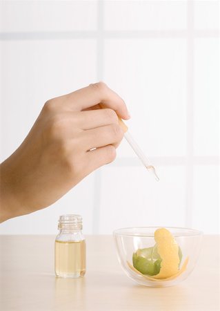 eye dropper and pipette woman - Woman's hand dropping oil into bowl with lemon zest Stock Photo - Premium Royalty-Free, Code: 632-01153505