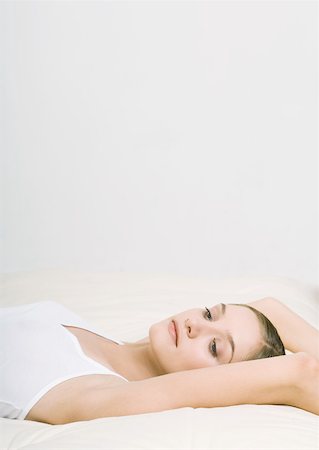 simsearch:632-01151438,k - Woman lying back on bed with arms over head Foto de stock - Sin royalties Premium, Código: 632-01153508