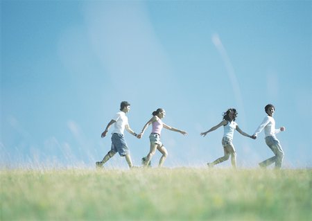 Two young couples walking hand in hand outside, girls reaching for each other's hands Stock Photo - Premium Royalty-Free, Code: 632-01153650