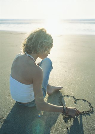 Girl sitting on beach, drawing heart in sand Foto de stock - Sin royalties Premium, Código: 632-01153674