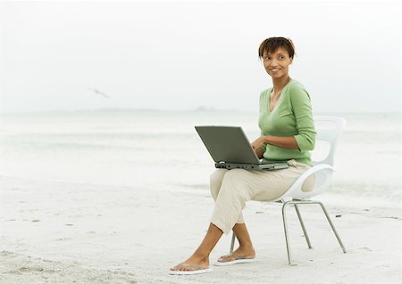 simsearch:632-03500777,k - Woman on beach, sitting in chair using laptop Foto de stock - Royalty Free Premium, Número: 632-01160313