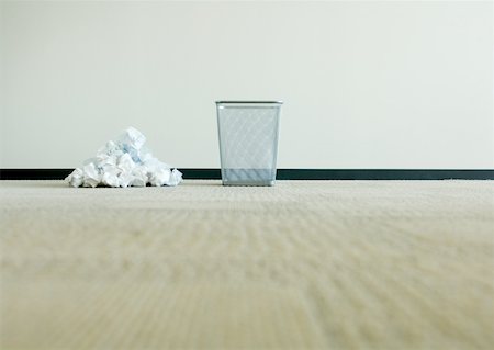 Pile of crumpled paper next to empty wastebasket Stock Photo - Premium Royalty-Free, Code: 632-01160388