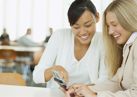 simsearch:632-01155400,k - Two young business women looking at cell phone together Foto de stock - Sin royalties Premium, Código: 632-01160488