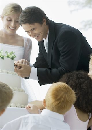 Groom cutting wedding cake Stock Photo - Premium Royalty-Free, Code: 632-01160660