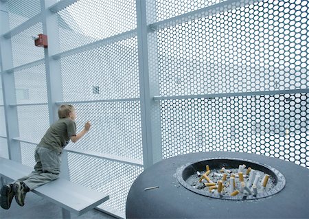 Child looking through walls made of metal grating Stock Photo - Premium Royalty-Free, Code: 632-01160735