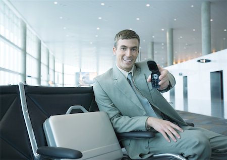 simsearch:696-03397972,k - Homme d'affaires tenu bon téléphone portable dans le salon de l'aéroport Photographie de stock - Premium Libres de Droits, Code: 632-01160746
