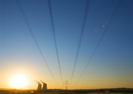 Nuclear cooling towers and electric wires and pylon at sunset Stock Photo - Premium Royalty-Free, Code: 632-01162321