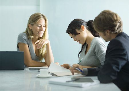 Three adults sitting at table, looking over document Stock Photo - Premium Royalty-Free, Code: 632-01194108