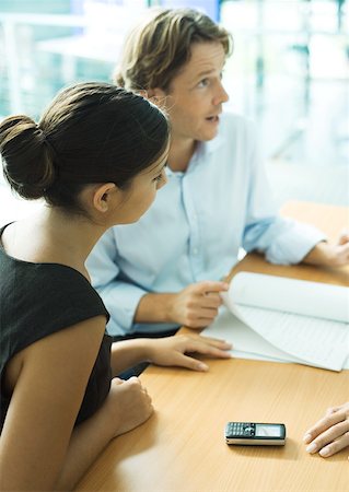 Young professional couple with contract, man speaking and looking out of frame Stock Photo - Premium Royalty-Free, Code: 632-01194133