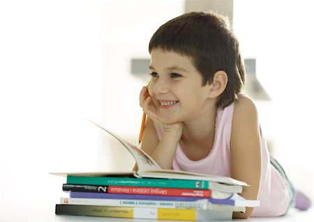 simsearch:632-05816453,k - Enfant allongé à côté de la pile de livres, souriant Photographie de stock - Premium Libres de Droits, Code: 632-01193792