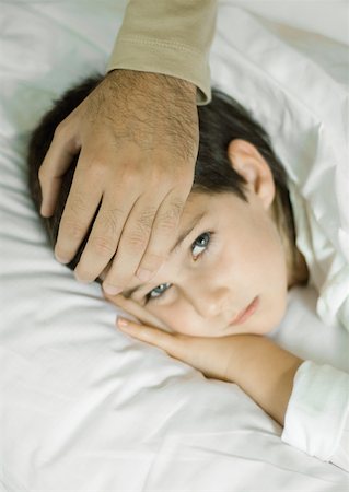 father sick child - Child lying in bed, father's hand on forehead Stock Photo - Premium Royalty-Free, Code: 632-01193868