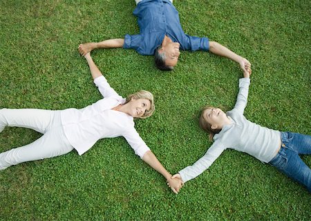 simsearch:632-05400916,k - Mature couple and granddaughter lying on grass, holding hands Foto de stock - Royalty Free Premium, Número: 632-01193998