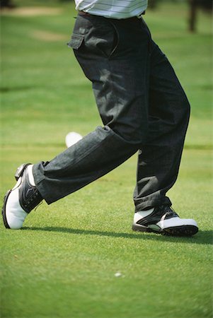 Golfer in mid swing, low section Fotografie stock - Premium Royalty-Free, Codice: 632-01234605