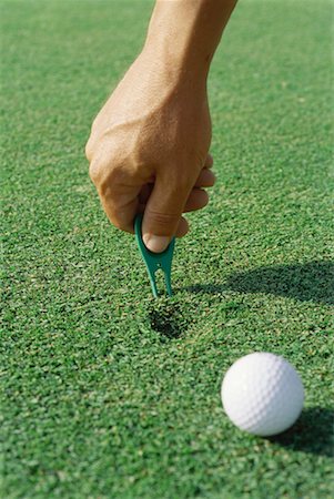 simsearch:632-01234708,k - Golfer using divot repair tool on turf, close-up of hand Foto de stock - Sin royalties Premium, Código: 632-01234710