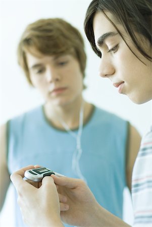 Teenage friends listening to MP3 player together Foto de stock - Sin royalties Premium, Código: 632-01276657