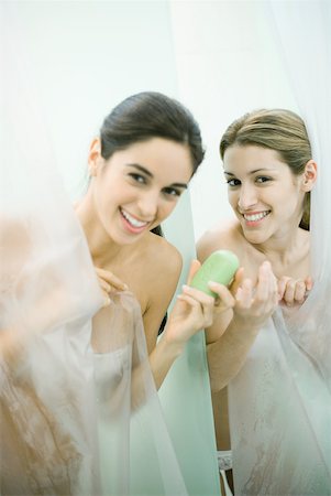 simsearch:632-01277233,k - Two young women taking showers, one handing the other a bar of soap Fotografie stock - Premium Royalty-Free, Codice: 632-01277233