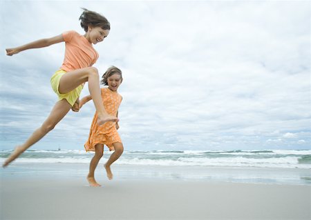 simsearch:632-02745223,k - Two girls running and jumping on beach Stock Photo - Premium Royalty-Free, Code: 632-01270471