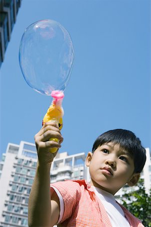 Boy making bubbles with bubble gun Stock Photo - Premium Royalty-Free, Code: 632-01270712