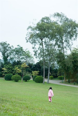 Girl walking across grass, rear view Stock Photo - Premium Royalty-Free, Code: 632-01270831