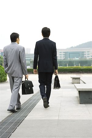 Two businessmen walking in office park, rear view Stock Photo - Premium Royalty-Free, Code: 632-01270844