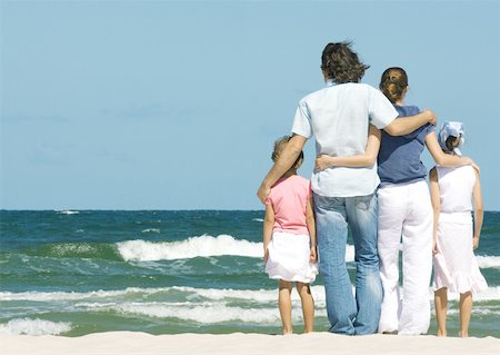 simsearch:696-03401542,k - Family standing next to surf, facing ocean, rear view Foto de stock - Royalty Free Premium, Número: 632-01271049