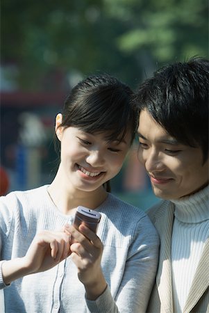 simsearch:696-03401266,k - Young couple using cell phone together Fotografie stock - Premium Royalty-Free, Codice: 632-01271114