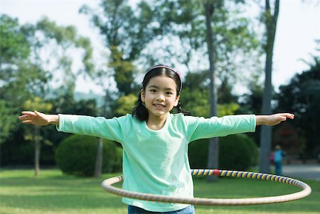 Girl playing with plastic hoop Stock Photo - Premium Royalty-Free, Code: 632-01271211