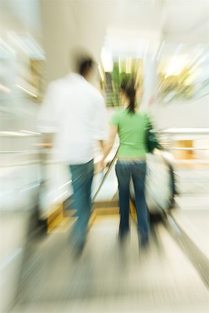 retail business on the go - Couple walking toward escalator, blurred motion Stock Photo - Premium Royalty-Free, Code: 632-01271229