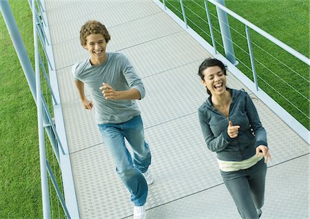 simsearch:695-03373971,k - Teenage couple running on walkway, laughing, high angle view Foto de stock - Royalty Free Premium, Número: 632-01271296