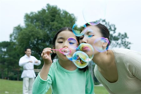 Girl and mother blowing bubbles Stock Photo - Premium Royalty-Free, Code: 632-01271293