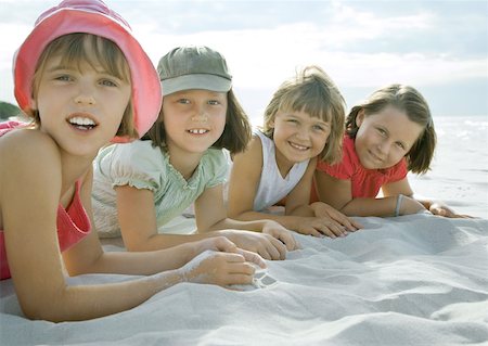 simsearch:632-03424709,k - Four girls lying on beach, smiling at camera, close-up Stock Photo - Premium Royalty-Free, Code: 632-01271322