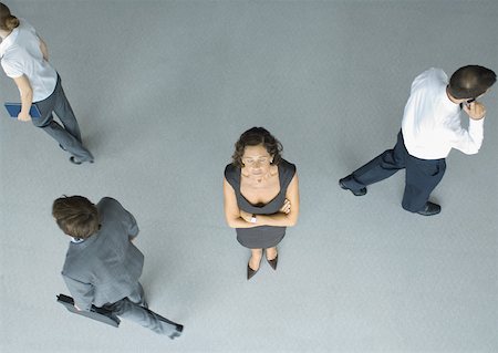 Woman standing with arms folded and eyes closed while people pass by, full length, high angle view Stock Photo - Premium Royalty-Free, Code: 632-01271458