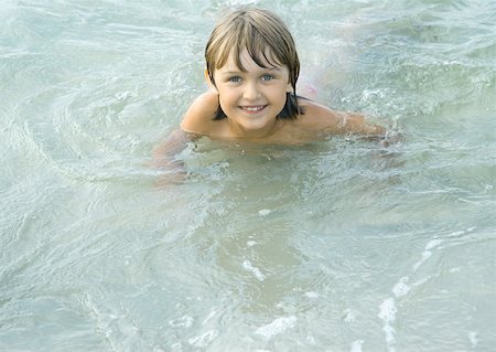 Girl wading in shallow water, looking at camera Stock Photo - Premium Royalty-Free, Code: 632-01271463
