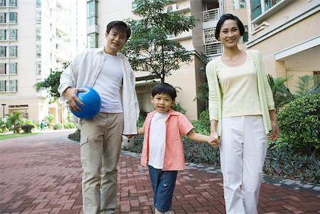 simsearch:696-03401226,k - Family standing by apartment complex, smiling at camera, father holding ball Stock Photo - Premium Royalty-Free, Code: 632-01271828