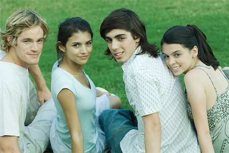 simsearch:696-03401497,k - Vier junge Freunde sitzen auf Gras, nebeneinander, über die Schultern in die Kamera schauen Stockbilder - Premium RF Lizenzfrei, Bildnummer: 632-01379317