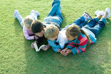 simsearch:632-05400916,k - Children lying on grass together, reading Foto de stock - Royalty Free Premium, Número: 632-01379795