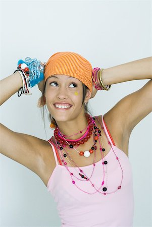simsearch:695-03376668,k - Teenage girl wearing lots of jewelry, hands behind head, looking up, smiling, portrait Stock Photo - Premium Royalty-Free, Code: 632-01380073