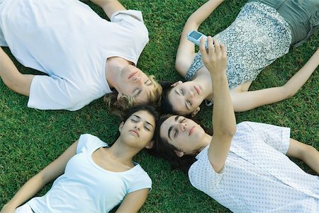 simsearch:695-03375661,k - Groupe de jeunes amis couché sur l'herbe avec ensemble de têtes, les yeux fermés, une photo prise avec le téléphone portable Photographie de stock - Premium Libres de Droits, Code: 632-01380147