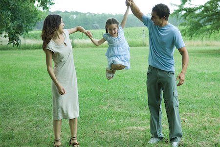 Man and woman holding up daughter in the air Stock Photo - Premium Royalty-Free, Code: 632-01380221