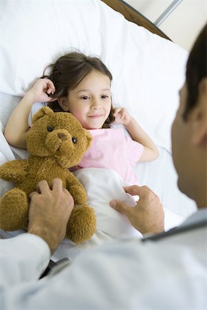 shy child adults - Girl lying in hospital bed, smiling up at doctor Stock Photo - Premium Royalty-Free, Code: 632-01380282