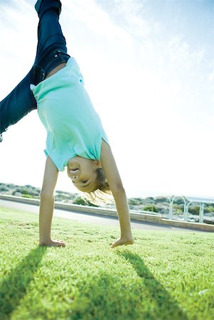 Girl doing cartwheel on grass Stock Photo - Premium Royalty-Free, Code: 632-01380333