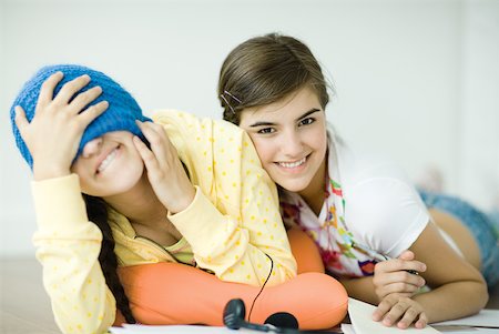 Two young female friends lying on floor, one covering eyes with knit hat Fotografie stock - Premium Royalty-Free, Codice: 632-01380429