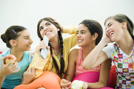 Four young female friends sitting together, smiling, snacking Stock Photo - Premium Royalty-Free, Code: 632-01380438