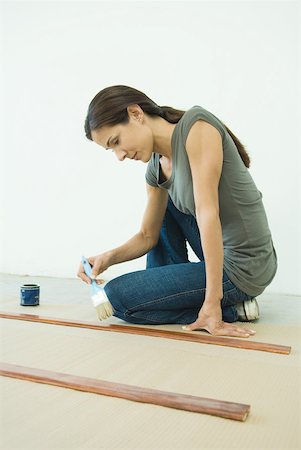Woman applying varnish to pieces of wood Stock Photo - Premium Royalty-Free, Code: 632-01380529