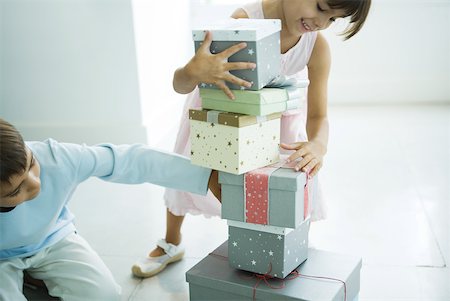 Brother and sister taking presents from stack Stock Photo - Premium Royalty-Free, Code: 632-01380636